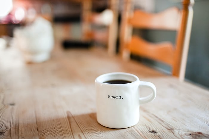 a mug of coffee with the word 'begin' on it